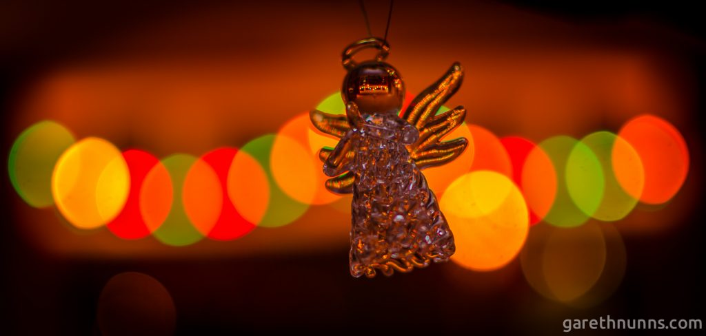 Christmas tree angel with blurred Christmas lights behind